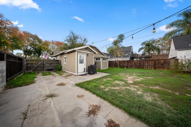 a view of a house with backyard and a tree