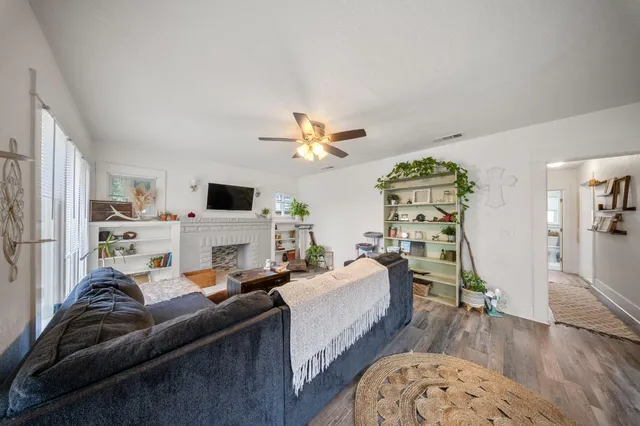 a living room with furniture a fireplace and wooden floor