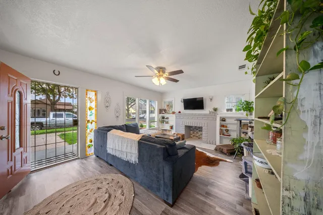 a living room with furniture a flat screen tv and a floor to ceiling window