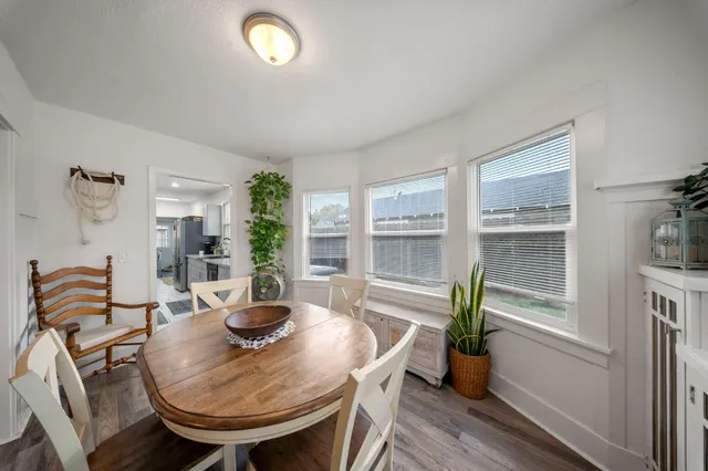 a dining room with furniture potted plants and wooden floor