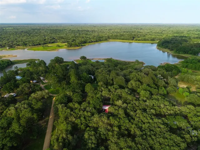 an aerial view of a houses with a yard and lake view
