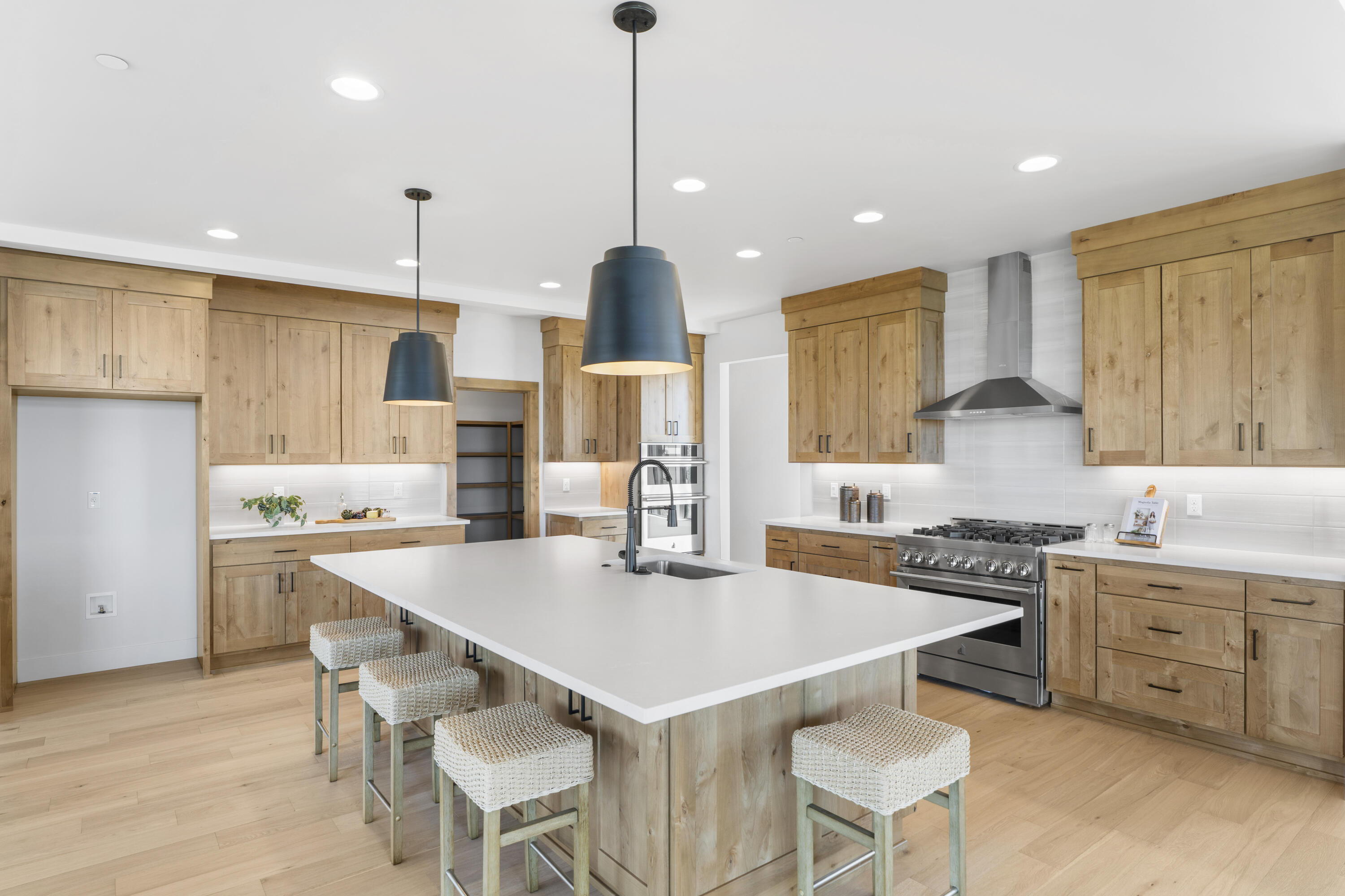 16883 Southwest Paragon Court Powell Butte, OR 97753 - Photo 7 of 42 The kitchen features an oversized island and spacious work areas. The gas range and hood are separate from an oven and microwave