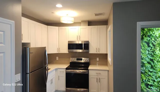 a kitchen with a refrigerator and a stove