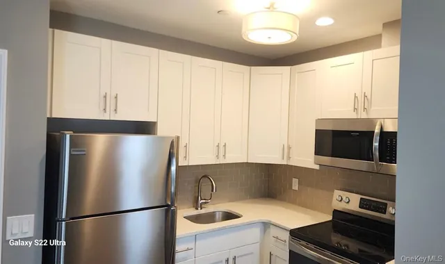 a kitchen with stainless steel appliances a refrigerator and a stove top oven