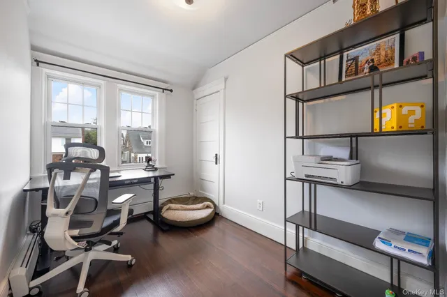 a view of a workspace with furniture and a window
