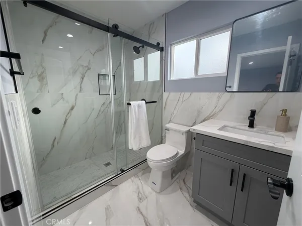 a bathroom with a sink a toilet and shower