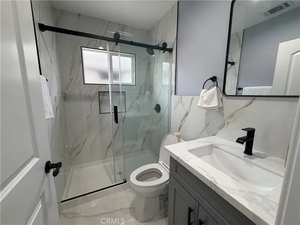 a bathroom with a sink a toilet and shower
