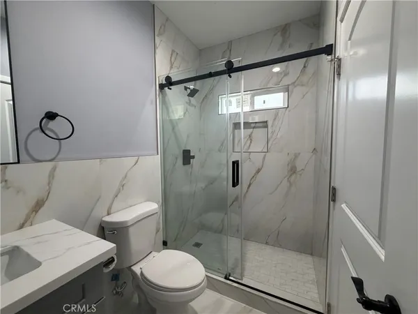 a bathroom with a toilet and a shower