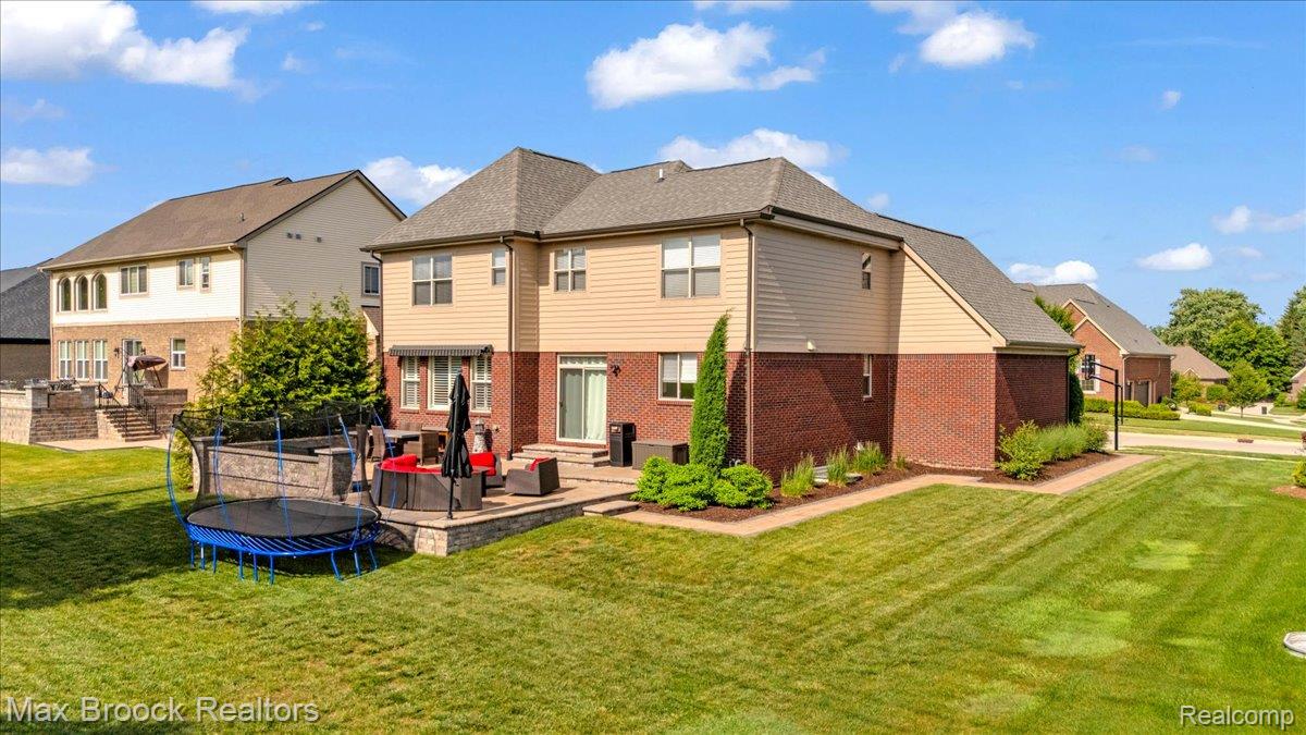 1126 Queensboro Drive Rochester, MI 48307 - Photo 51 of 66 Expansive green lawn surrounding a two-story residence featuring a brick and siding exterior