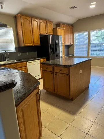 a kitchen with stainless steel appliances granite countertop a refrigerator and a sink