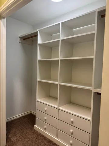 a view of walk in closet with empty racks