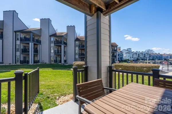 a view of a patio with table and chairs with wooden floor and fence
