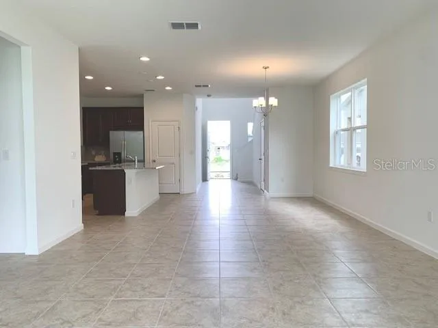 a view of a kitchen with a sink and an empty room
