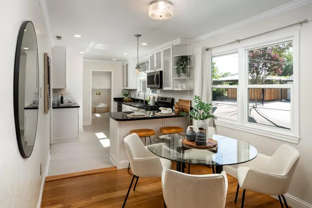 a large white kitchen with a large window and stainless steel appliances