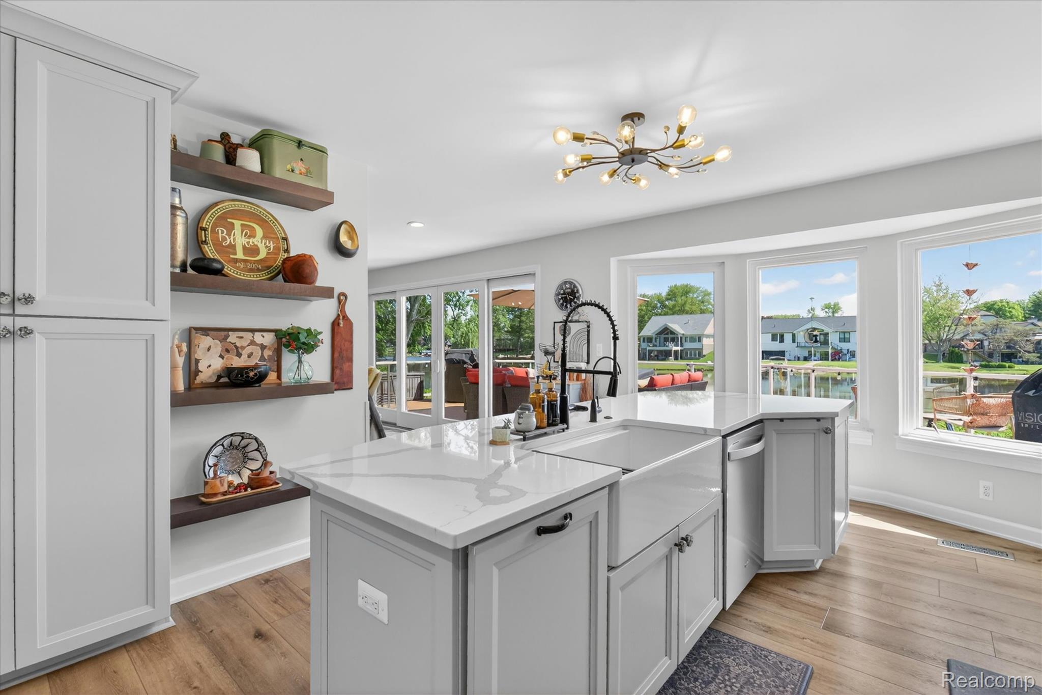 3860 East Commerce Road Commerce Township, MI 48382 - Photo 18 of 72 Kitchen island featuring light gray cabinetry, a white farmhouse sink, and a quartz countertop
