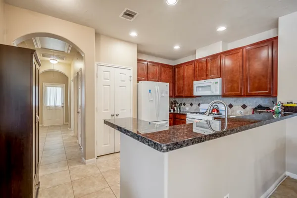 a kitchen with granite countertop cabinets and refrigerator