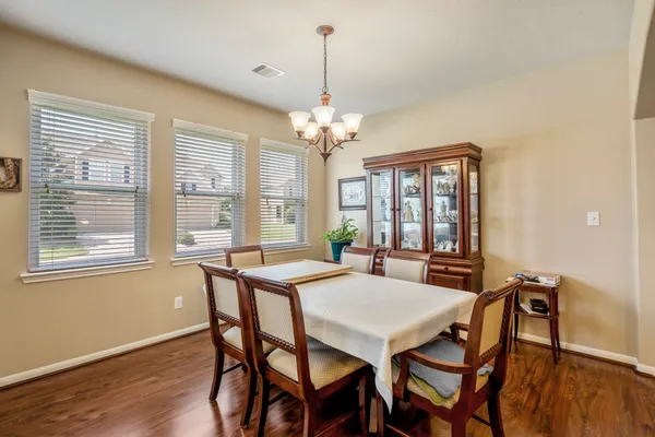 a view of a dining room with furniture wooden floor and chandelier