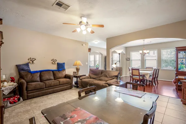 a living room with furniture a flat screen tv and a chandelier
