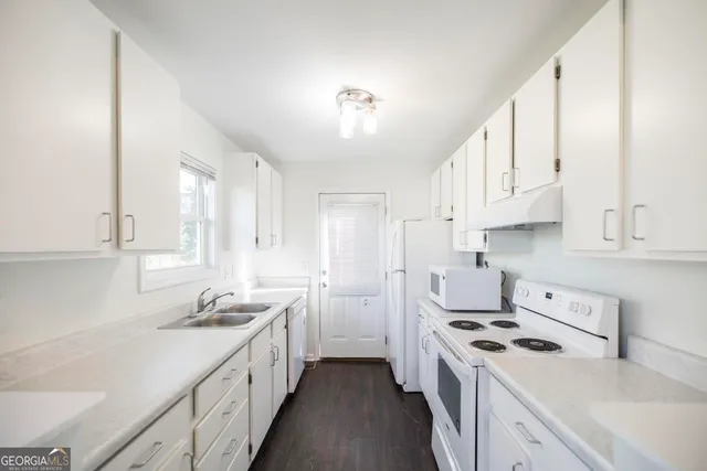 a kitchen with kitchen island white cabinets and white appliances