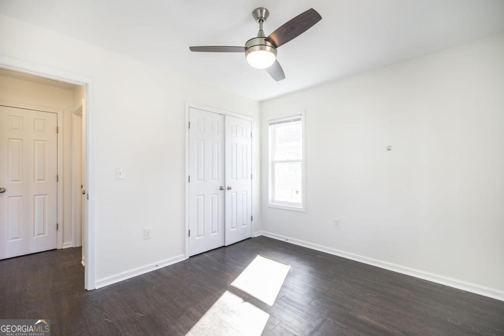 338 Monroe Street Macon, GA 31201 - Photo 19 of 25 an empty room with wooden floor ceiling fan and window