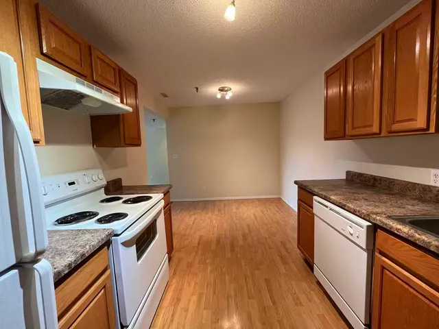 a kitchen with granite countertop a stove and a wooden floor