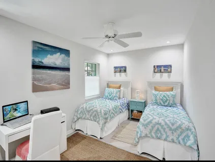 a bedroom with two beds and a painting on the wall