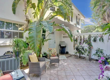 a view of a patio with couches table and chairs and potted plants