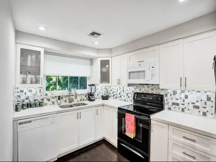 a kitchen with a stove sink and cabinets