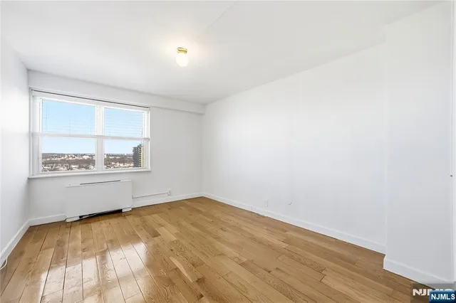 a view of a room with wooden floor and a window