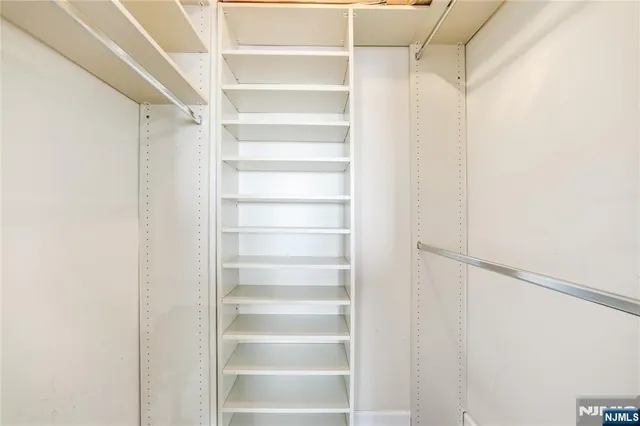 a view of walk in closet with empty racks