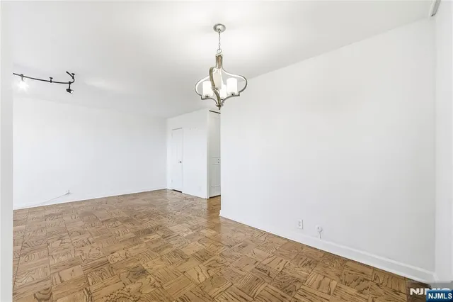 a view of a hallway with a chandelier fan and wooden floor