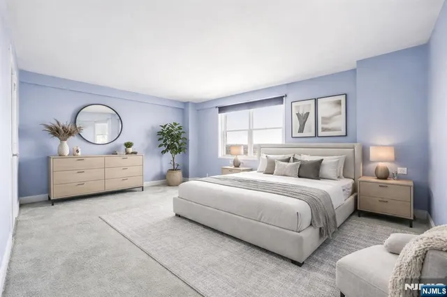 a spacious bedroom with a bed a closet and large mirror