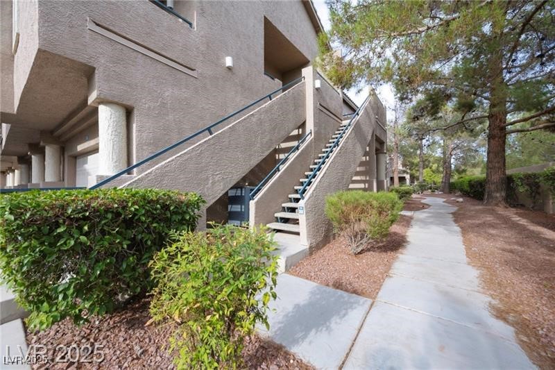 2152 Turquoise Ridge Street, Unit 202 Las Vegas, NV 89117 - Photo 3 of 23 View of property exterior featuring stairway and stucco siding