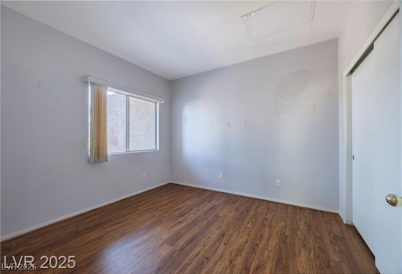 2152 Turquoise Ridge Street, Unit 202 Las Vegas, NV 89117 - Photo 9 of 23 Empty room featuring dark wood-style flooring and attic access