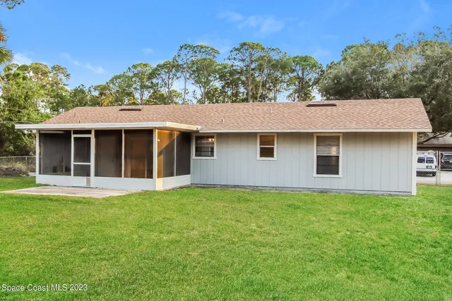 a view of a yard in front of a house with a large tree