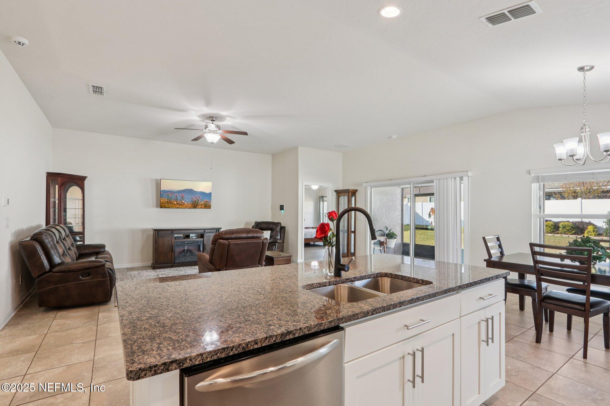 4100 Spring Creek Lane Middleburg, FL 32068 - Photo 14 of 58 a kitchen with granite countertop a sink and white cabinets