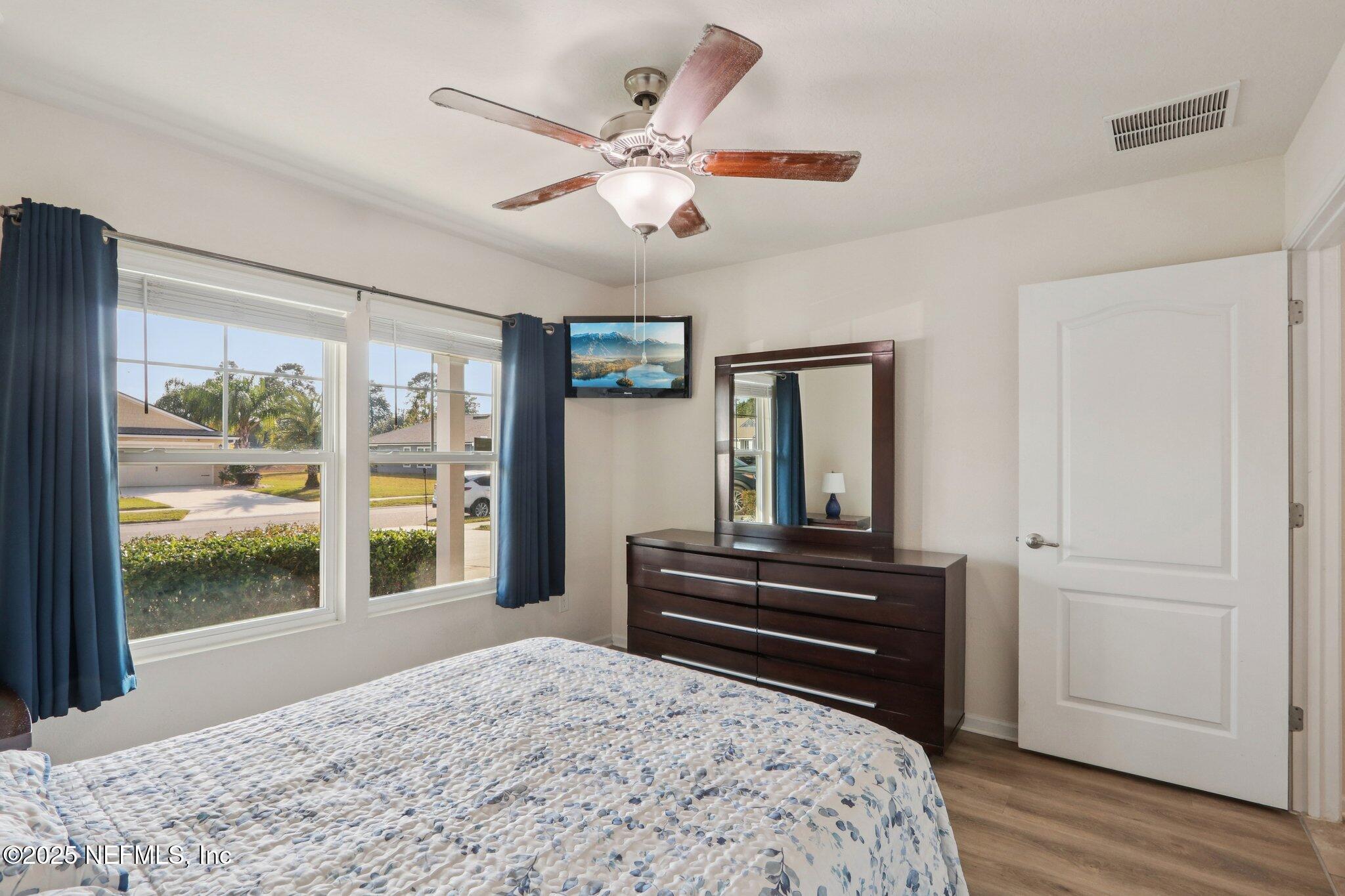 4100 Spring Creek Lane Middleburg, FL 32068 - Photo 18 of 58 a bedroom with a bed and a large window with wooden floor