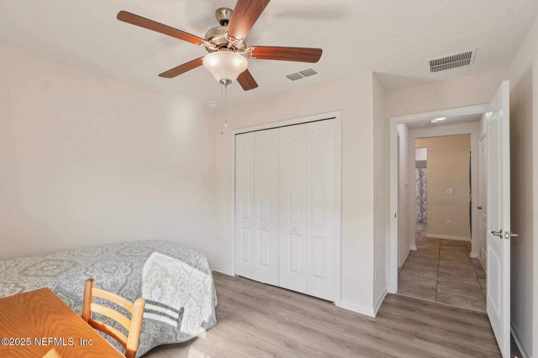 4100 Spring Creek Lane Middleburg, FL 32068 - Photo 21 of 58 wooden floor in an empty room with a chandelier fan