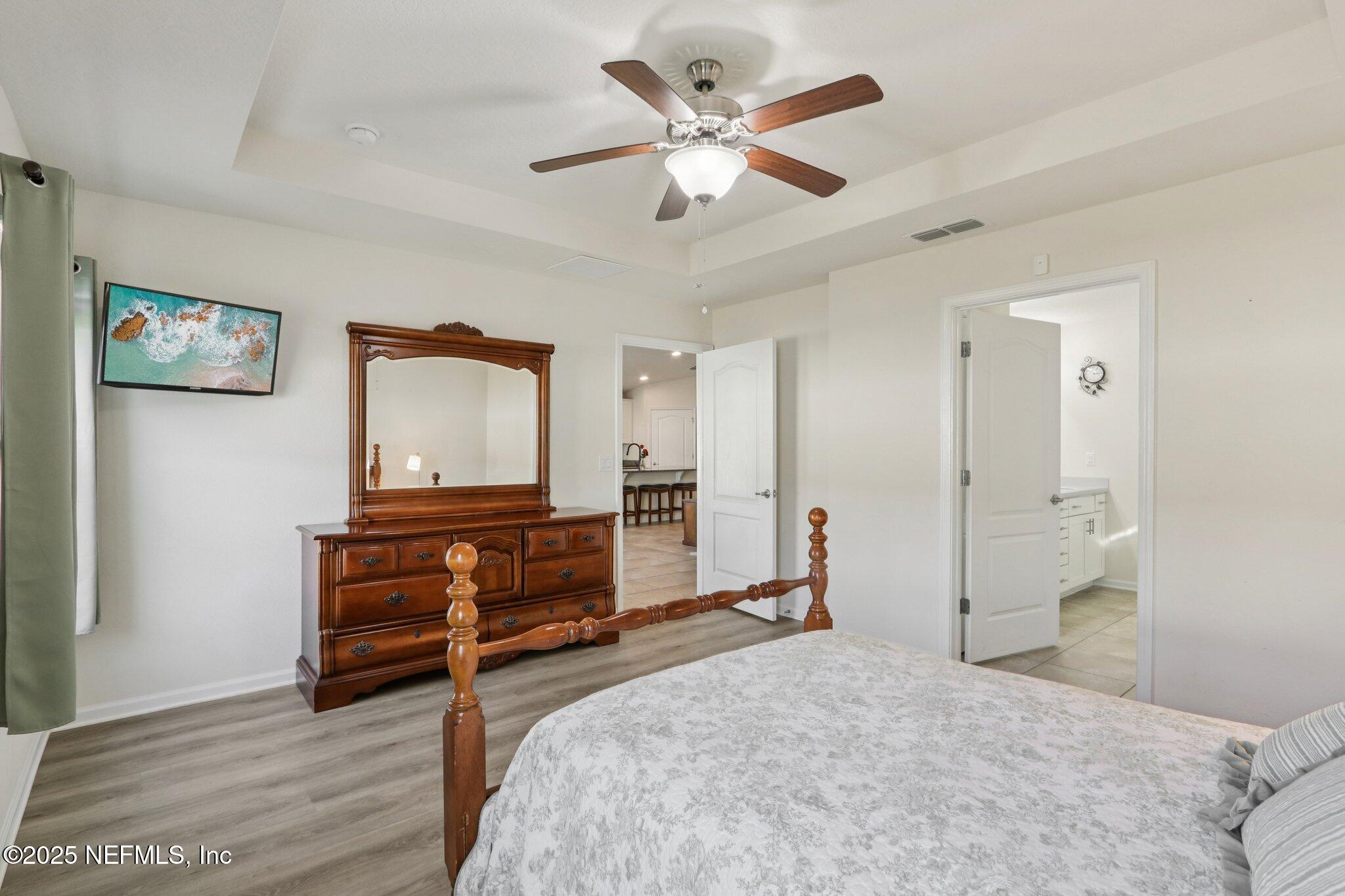 4100 Spring Creek Lane Middleburg, FL 32068 - Photo 24 of 58 a bedroom with a bed and a chandelier