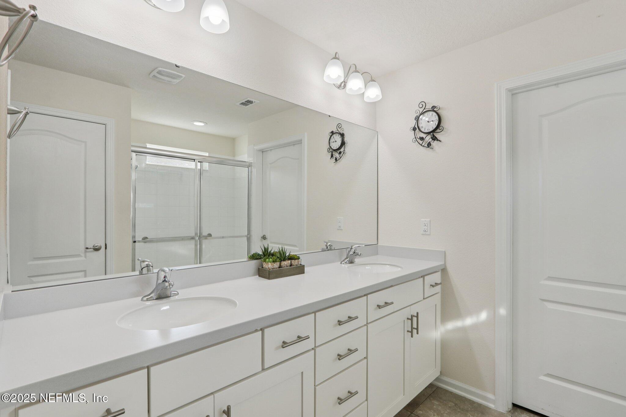 4100 Spring Creek Lane Middleburg, FL 32068 - Photo 25 of 58 a bathroom with a double vanity sink and mirror