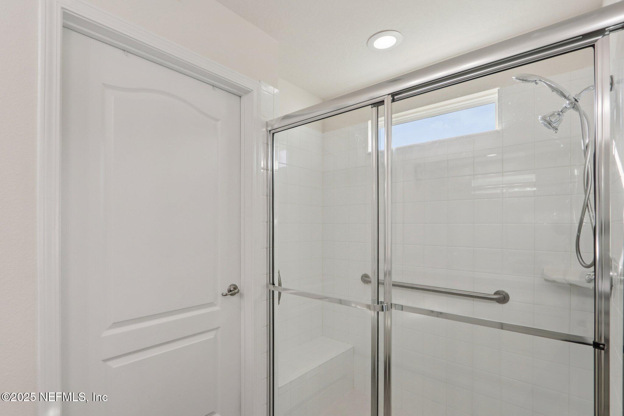 4100 Spring Creek Lane Middleburg, FL 32068 - Photo 26 of 58 a bathroom with a glass shower door