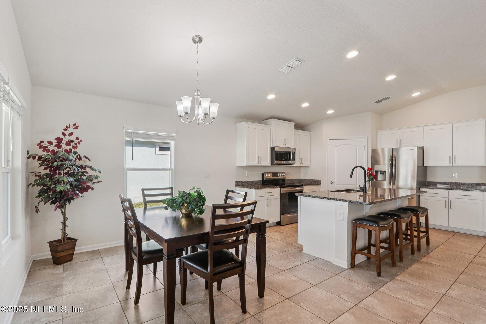 4100 Spring Creek Lane Middleburg, FL 32068 - Photo 9 of 58 a view of a dining room and kitchen with furniture wooden floor and a chandelier