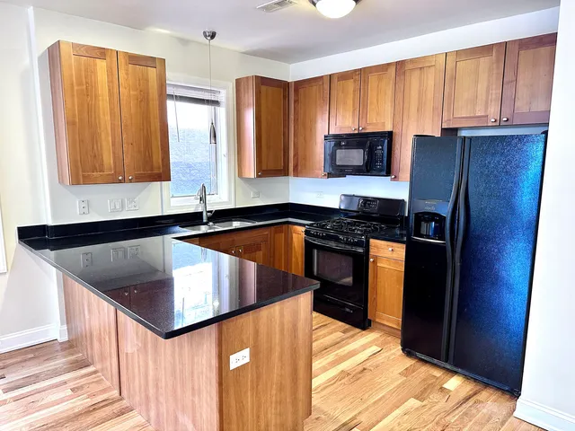 a kitchen with granite countertop a sink stainless steel appliances and cabinets