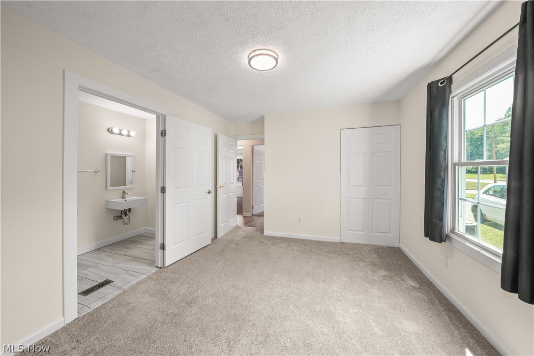 3796 North Santom Road Stow, OH 44224 - Photo 17 of 30 Room featuring light gray carpeting, a window with white trim, and a flush-mount ceiling light fixture