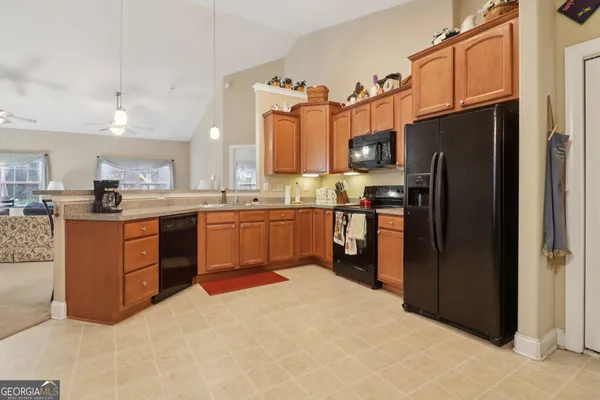 a kitchen with stainless steel appliances granite countertop a refrigerator and a stove top oven