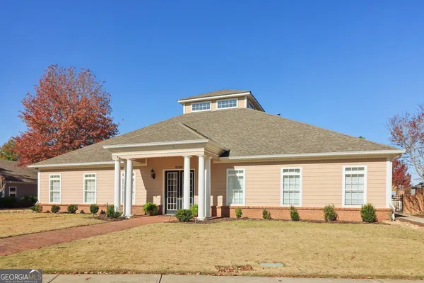 a front view of a house with a garden