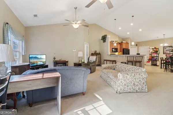 a living room with furniture and a dining table