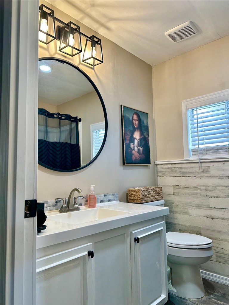 1395 Lause Road Bullhead City, AZ 86442 - Photo 22 of 34 Guest bathroom featuring a white vanity with integrated sink, brushed nickel faucet, and a round black-framed mirror