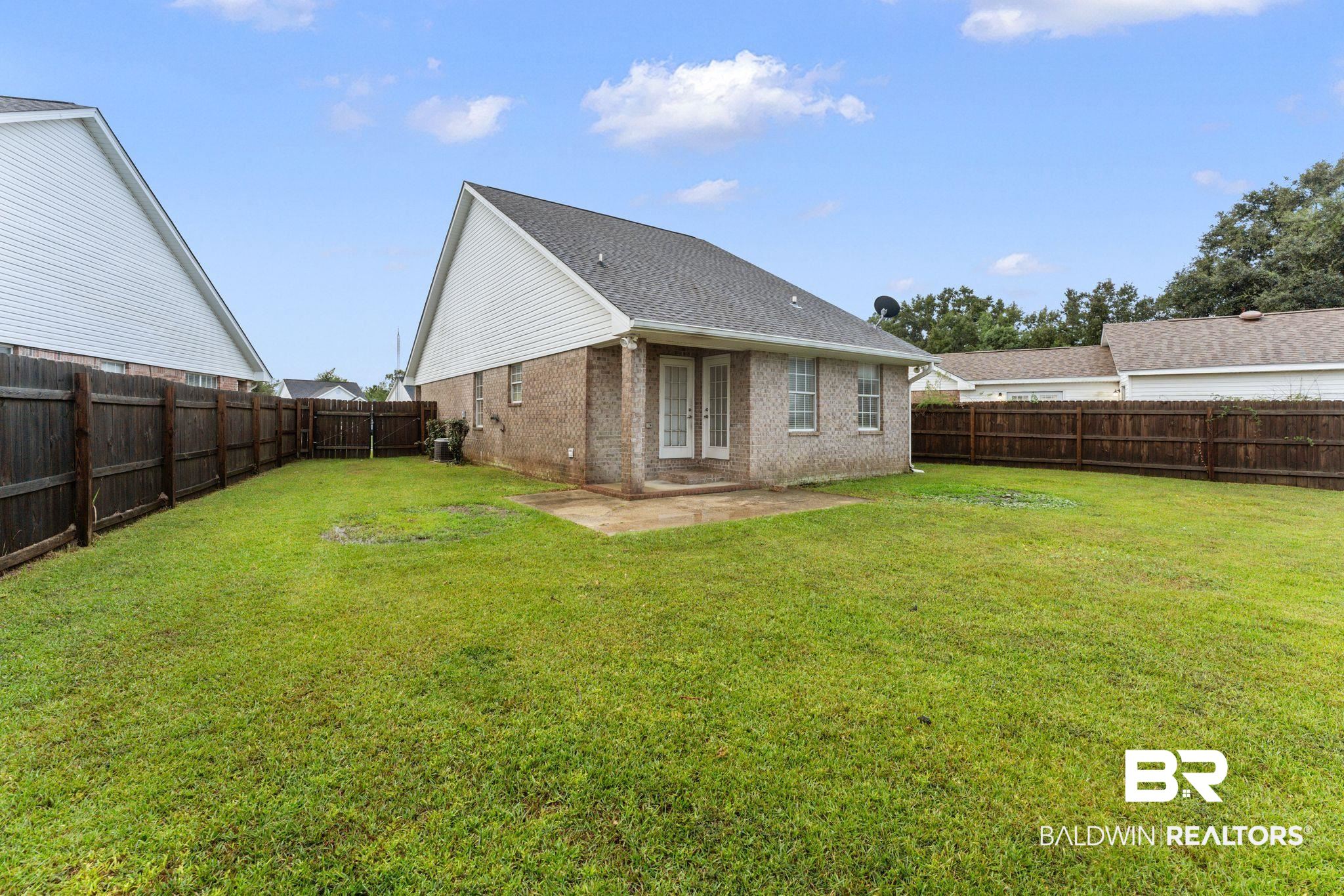 4009 Kendallbrook Loop Foley, AL 36535 - Photo 28 of 28 Rear view of property with a patio area, brick siding, a fenced backyard, and roof with shingles