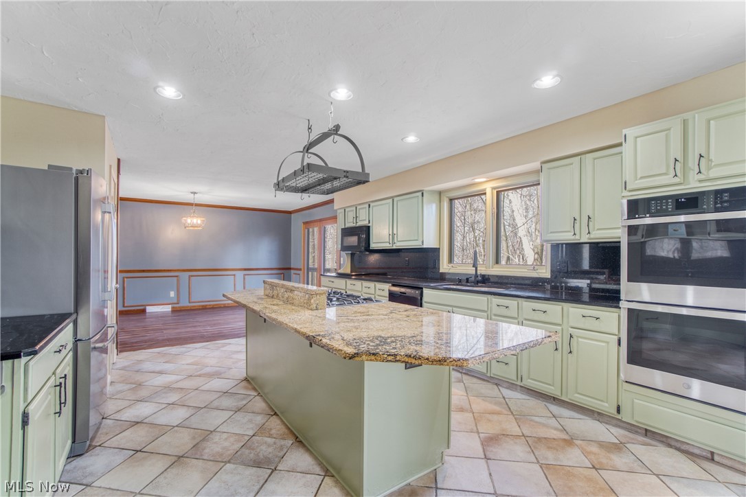 29329 Eddy Road Wickliffe, OH 44092 - Photo 9 of 50 Large kitchen island with a gas cooktop and hanging pot rack.